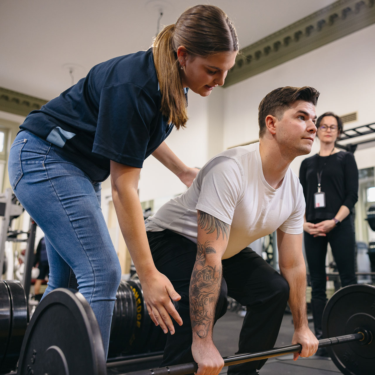Postgraduate female physiotherapy student assisting another student in the Fremantle campus gym 