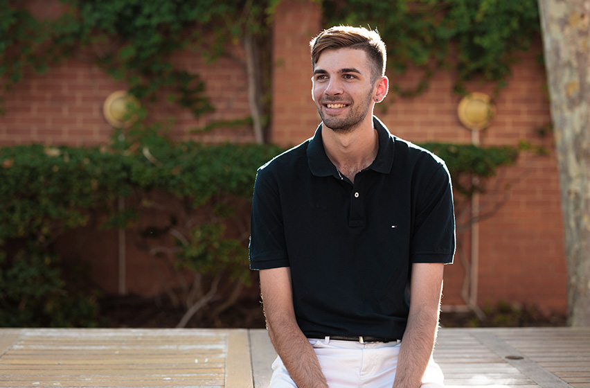 Postgraduate physiotherapy male student wearing a black shirt sitting on the Fremantle campus 
