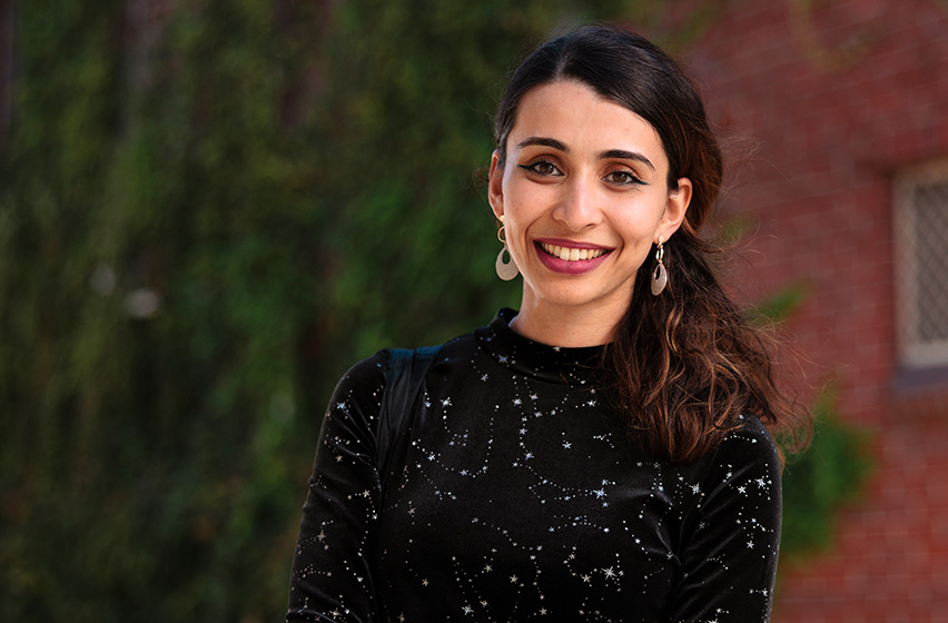 Postgraduate laws female student wearing a black top standing on campus 