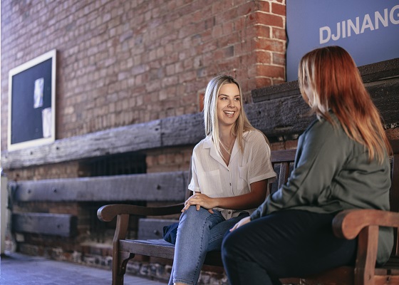 Two female counselling postgraduate students having a conversation in the campus 